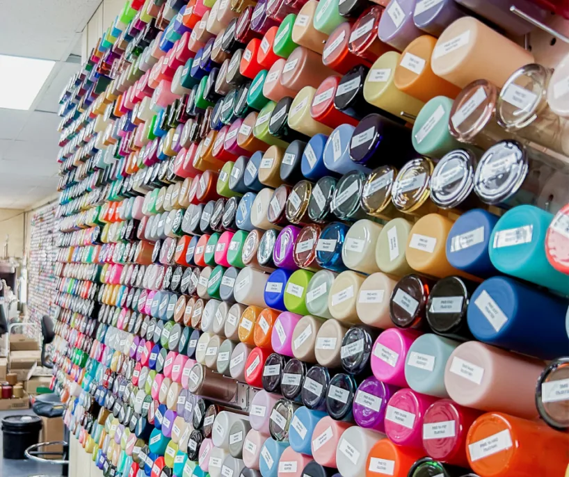 Wall of custom-decorated glass candle jars and containers in many colors and finishes