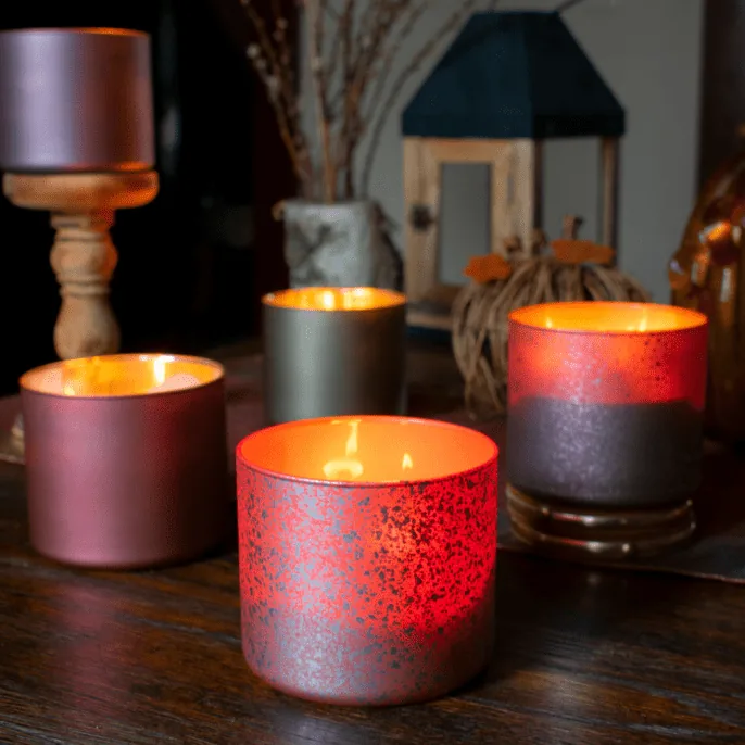 Red metallic decorated candle jars with lit candles